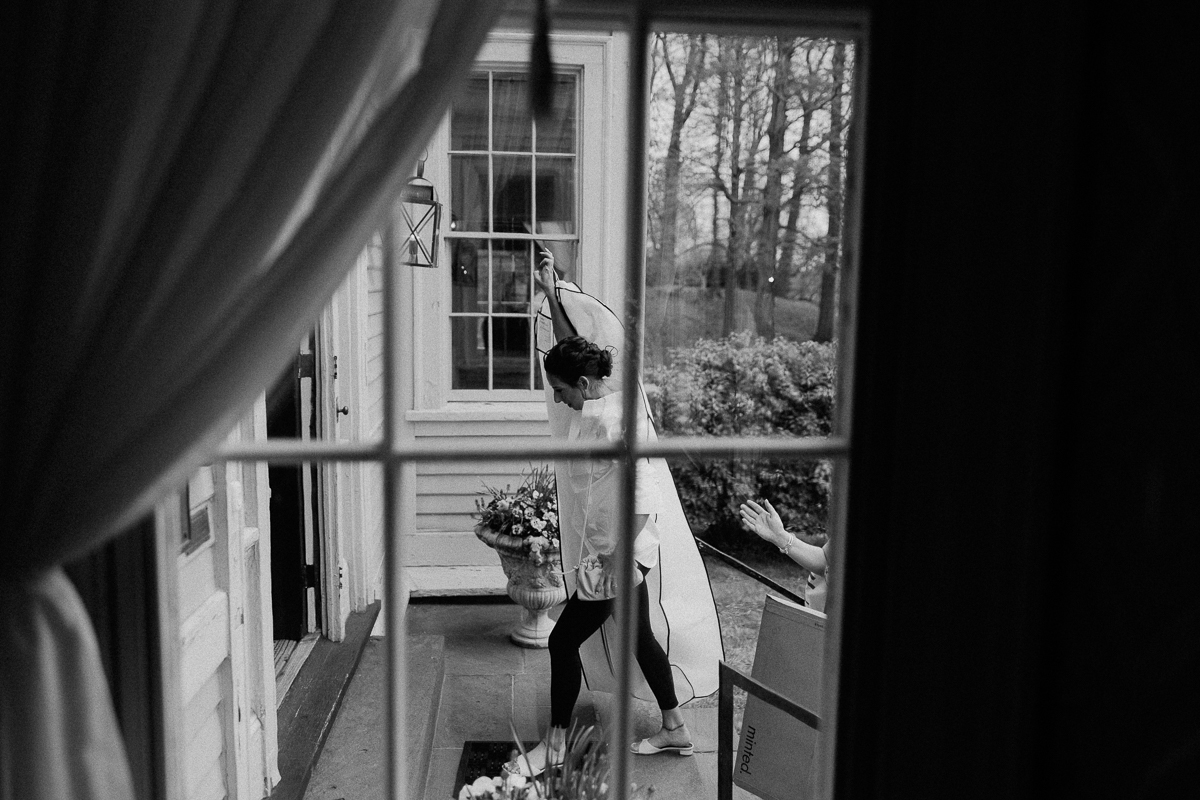 Bride carrying dress into the Lyman Estate for her wedding
