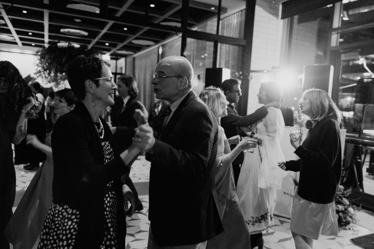 Guests enjoying a lively dance floor in a stylish venue, captured in black and white.