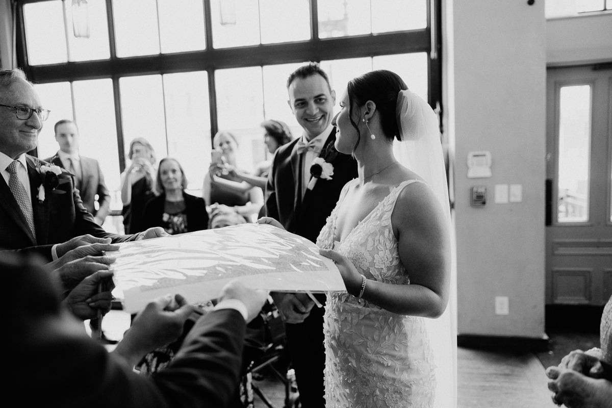 Bride and groom share a special moment during their wedding, surrounded by family and friends in a warm setting.