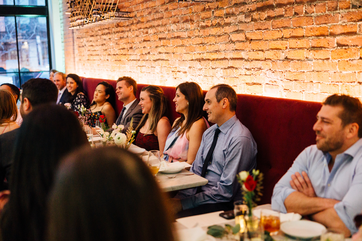 Guests enjoying a lively conversation at a beautifully arranged dinner table in a warm, intimate setting.