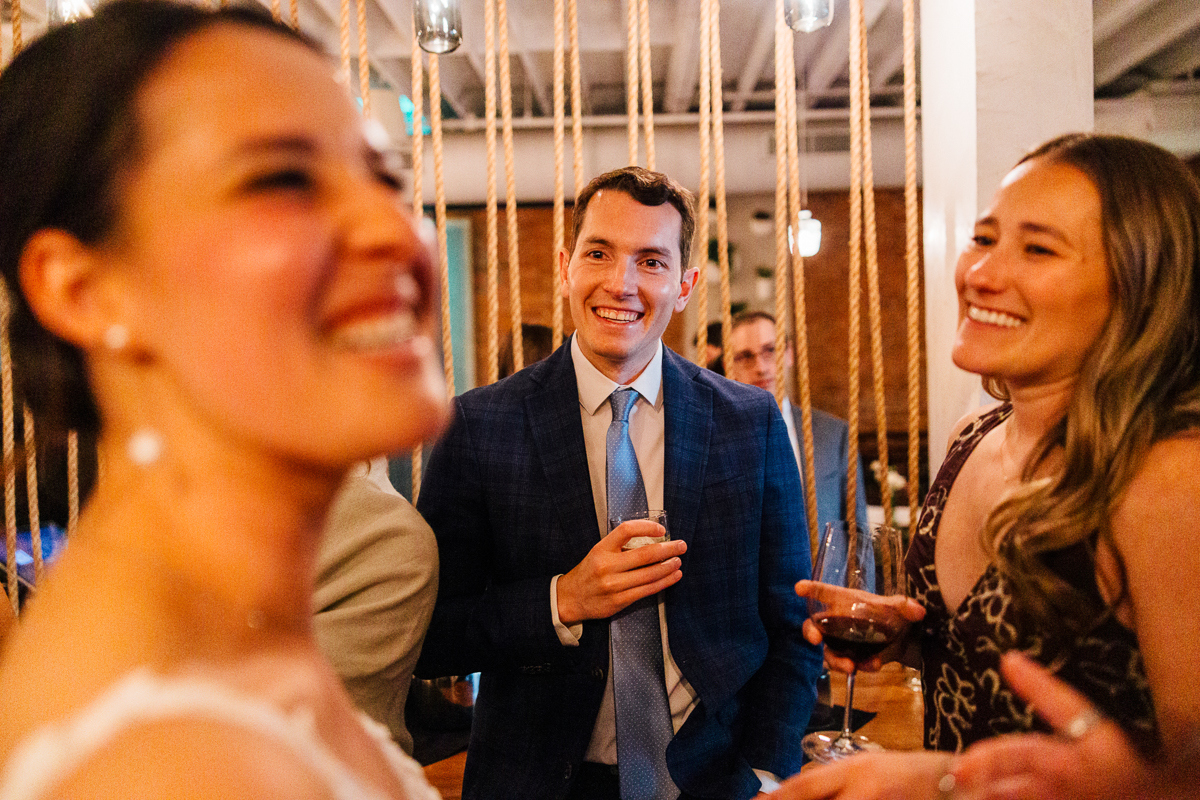 Group of friends enjoying a lively conversation at an event, captured in a warm and inviting atmosphere.