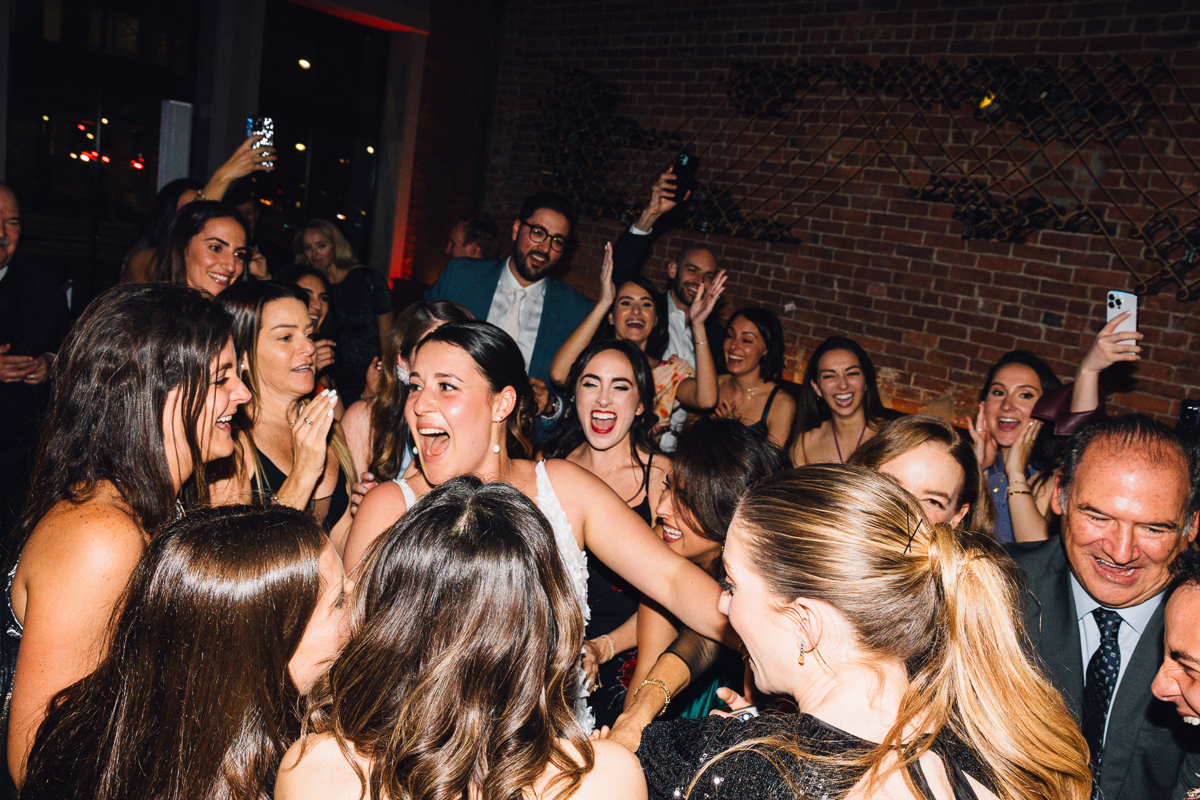 A joyful crowd of women celebrating together at a lively event, with laughter and excitement visible on their faces.