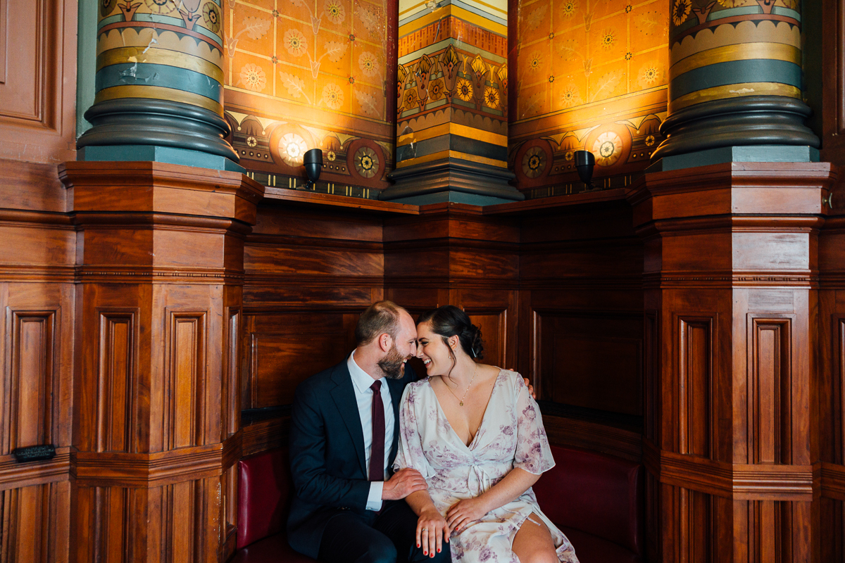 A couple sharing a joyful moment together in a beautifully designed wooden setting with colorful accents.