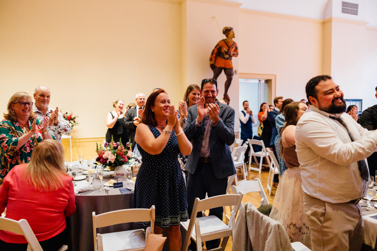 Guests applauding during a joyous event in a festive setting.